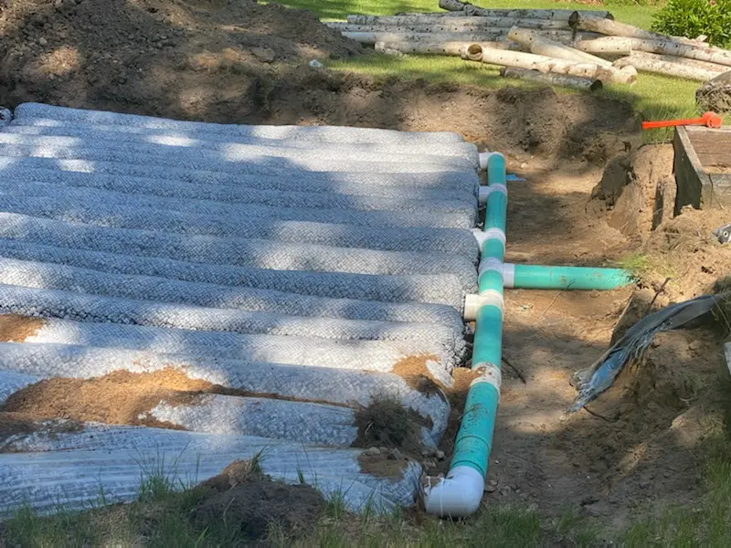 Drain field distribution pipes laid over stone bed