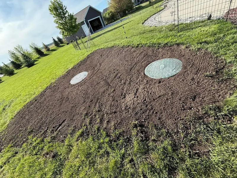 Exposed septic tank lids in a freshly graded lawn