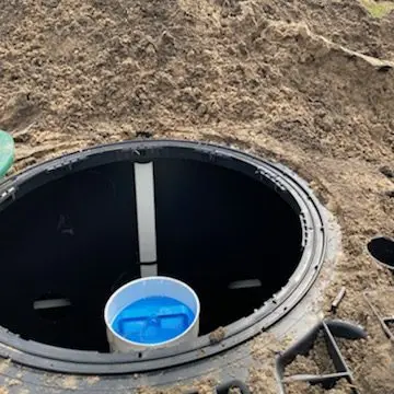 Open septic tank riser showing the outlet baffle